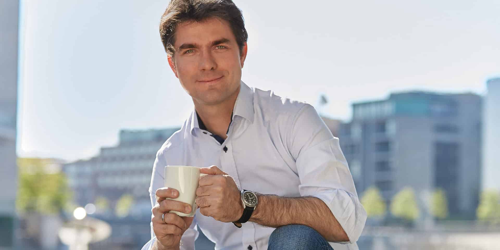 Mark Helfrich hält Kaffeetasse in der Hand