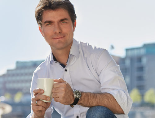 Mark Helfrich hält Kaffeetasse in der Hand